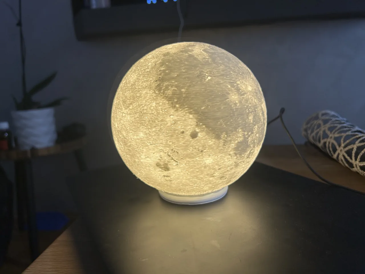Upaljena lampa u obliku Mjeseca na tamnoj polici.
